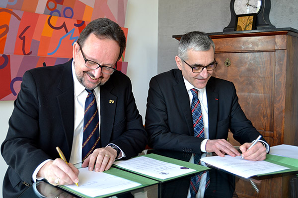 The presidents of Linfield College and University of Burgundy signing the new agreement