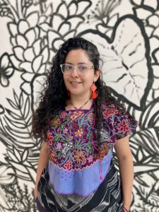Portrait of Lucia Torres in front of artwork