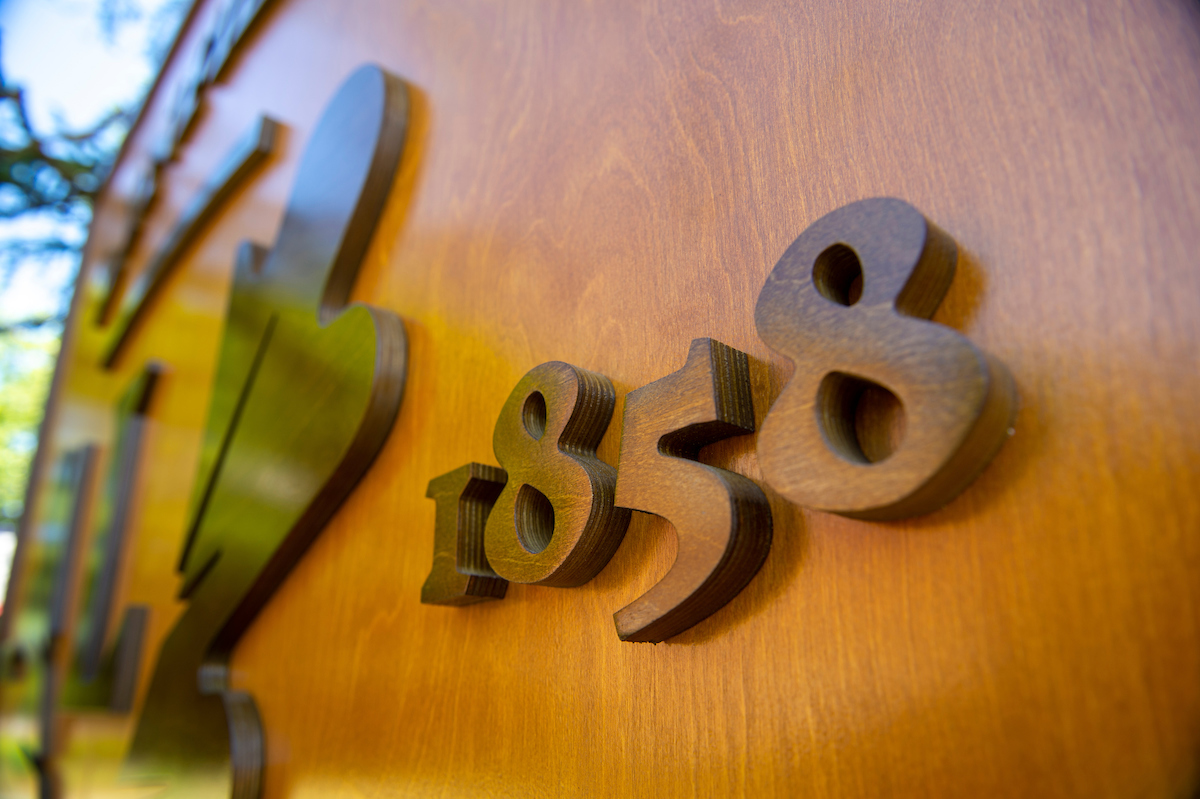 close up of university logo and founding year on wood backdrop