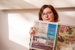 Jennifer Rauch holds a newspaper