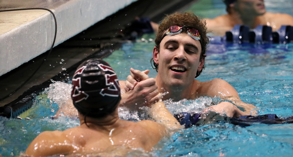 Garrett Sutton congratulates a fellow competitior at the Northwest Conference Swimming Championships. The men's and women's swimming teams wrapped up their 2021-22 season with conference championships in three relays and three individual events.