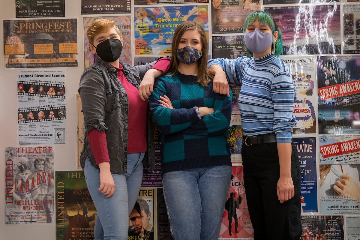Abbie Northrup, Hadley Nelson and Alea Tran stand in front of wall of theatre posters