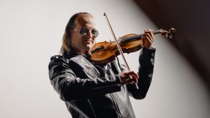 Aaron Meyer plays violin in leather jacket