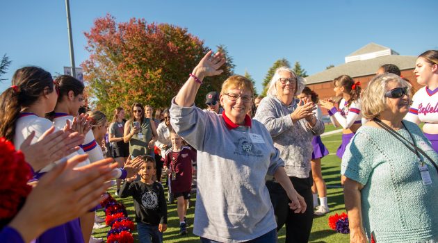 Former women athletes walk on football field
