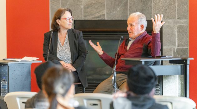 Oregonian editor Therese Bottomly and Pulitzer Prize-winning reporter Steve Kurkjian are seated and talking in front of a fireplace.