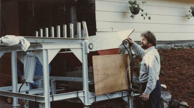 Oregon wine pioneer Dick Ponzi stands in front of a large, homemade press during the 1970s.