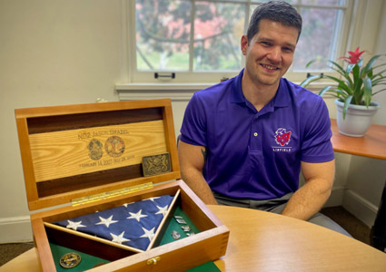 Jason Brazel in his office with his military shadow box