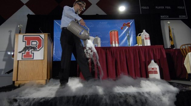 Physicist Bill Phillips does an on-stage demonstration with fog covering the floor.