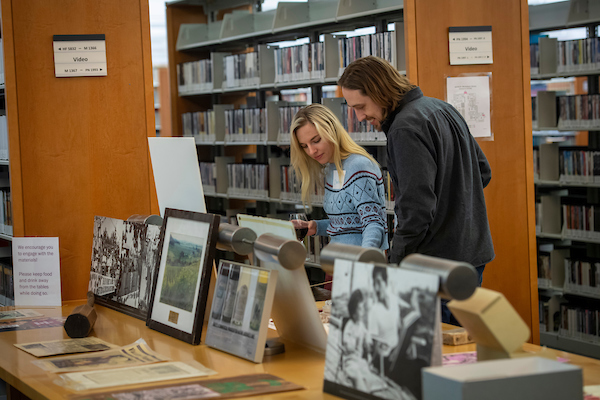 Patrons look at a display of historic wine photos.