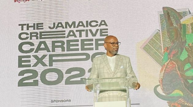 Linfield President Miles Davis speaks at a podium; "The Jamaica Creative Career Expo 2023" is written on the wall behind him.