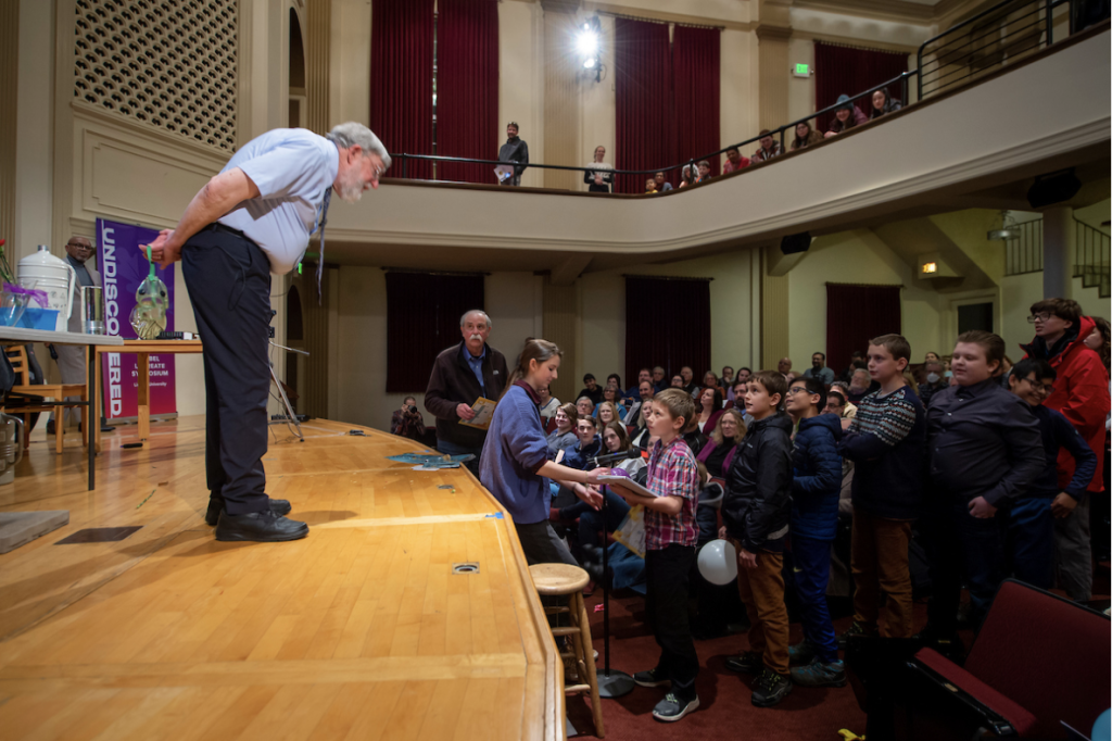 Bill Phillips bends down to hear a question asked by a young boy.