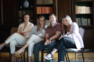 Four attendees of the YET! Business Symposium smile at the camera.