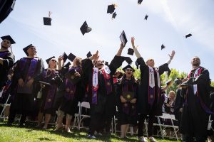 Student throw caps into air at Commencement 2023.