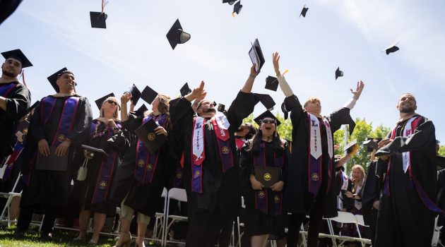 Student throw caps into air at Commencement 2023.
