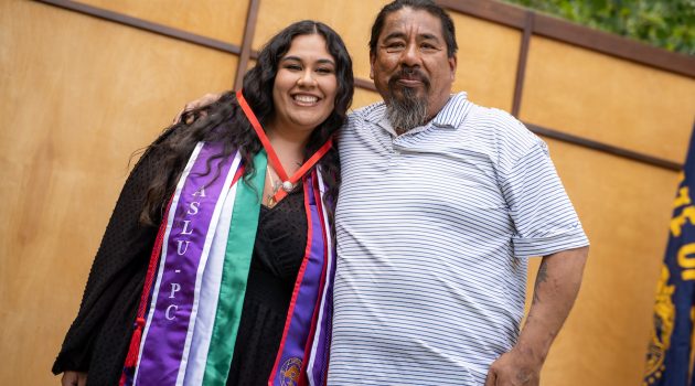 Student and guest pose after receiving the school pin.