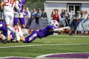 A Linfield football player dives for a ball during the Sept. 30 game against Willamette. 