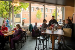Patrons sit in a spacious wine tasting room