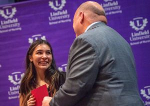 Dean Paul Smith congratulates graduate at December 2023 pinning ceremony.