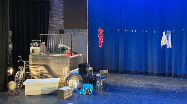 Stage set for "Too Much Light Makes the Baby Go Blind," featuring random piles of objects