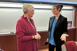 Two women have a spirited discussion in a college classroom