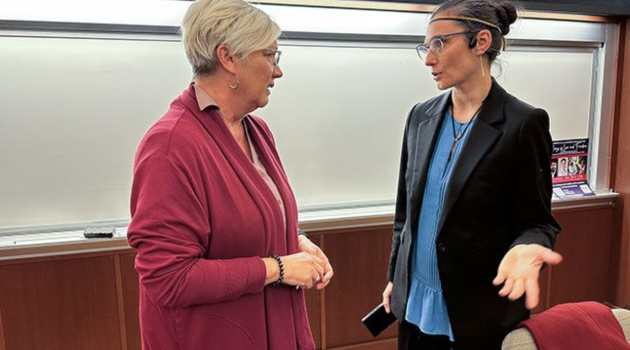 Two women have a spirited discussion in a college classroom