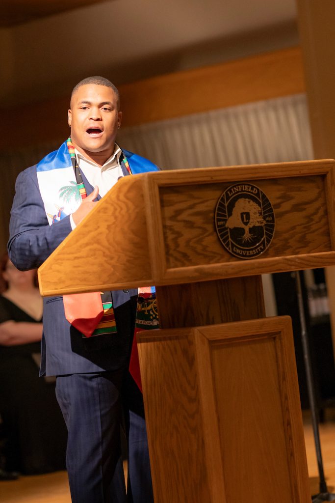 A student speaker stands at a podium during Linfield University’s Baccalaureate.