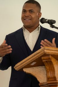 A student speaker stands at the podium during the Black Excellence Ceremony at Linfield University.