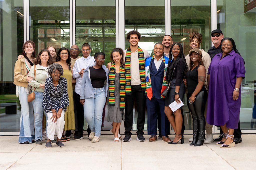 Students wearing a kente-striped stoles pose with family and faculty members during the Black Excellence Ceremony at Linfield University.