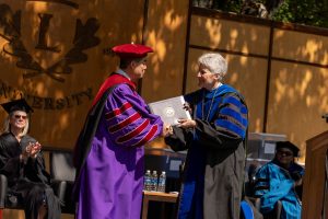 President Becky Johnson hands Shawn Chen an honorary doctorate speaks during the 2024 Linfield University Commencement.