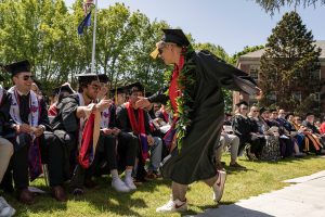 Students dressed in graduation caps and gowns celebrate during the 2024 Linfield University Commencement.