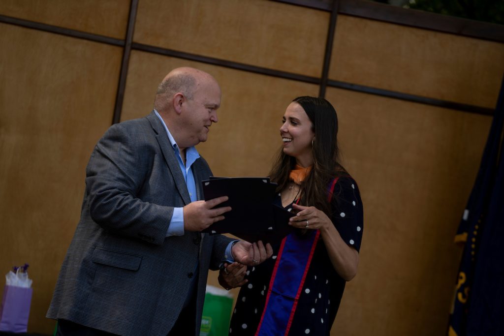 Dean Paul Smith greets a graduate at the Linfield University School of Nursing 2024 pinning ceremony.