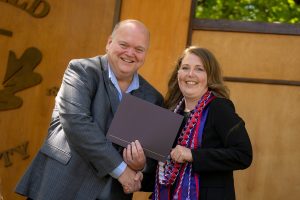 Dean Paul Smith greets a graduate at the Linfield University School of Nursing 2024 pinning ceremony.