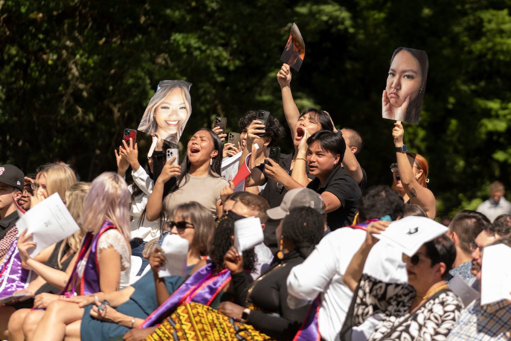 A family stands and cheers for their graduate during the Linfield University School of Nursing pinning ceremony.