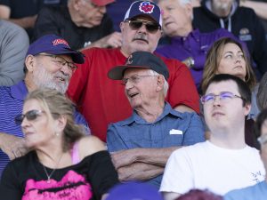 Two people talking in the stands at the football game during Linfield Homecoming 2024