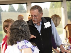 People smiling and talking during an event at Linfield Homecoming 2024