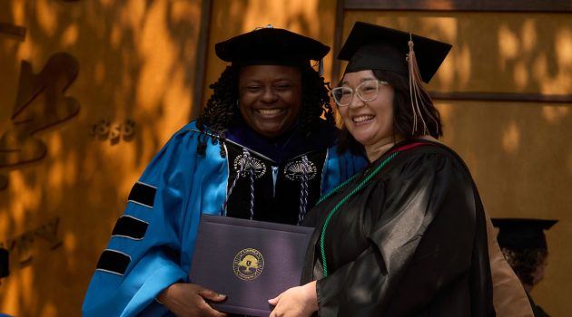Dean Jennifer Madden poses on the Commencement stage with Azia Salbego
