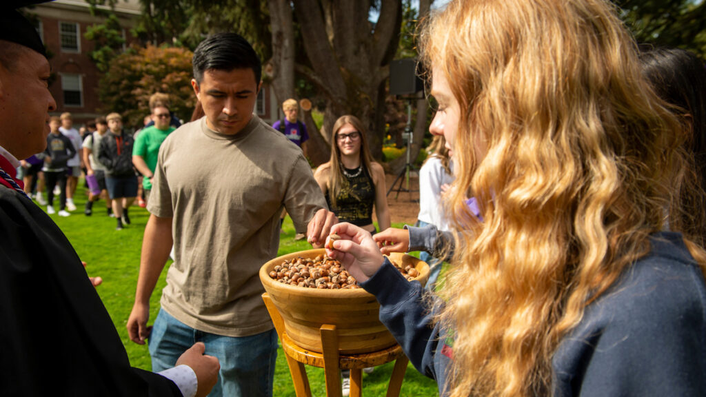 Students take their acorns from the bowl made from the Old Oak