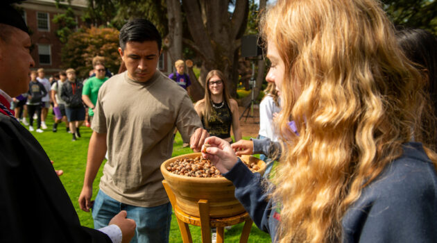 Students take their acorns from the bowl made from the Old Oak