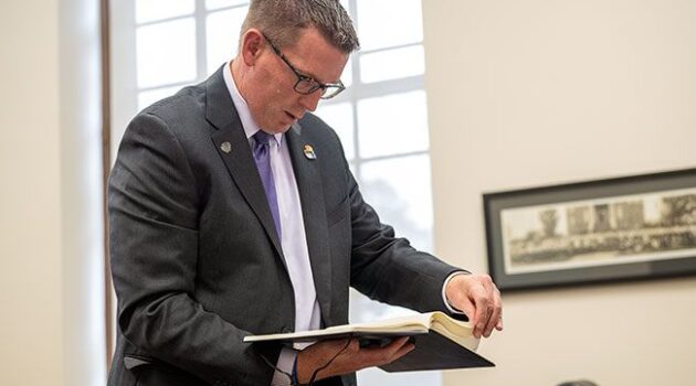Mark Blegen looks through a binder of enrollment figures.