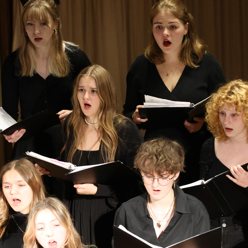 Members of the choir perform, holding song binders