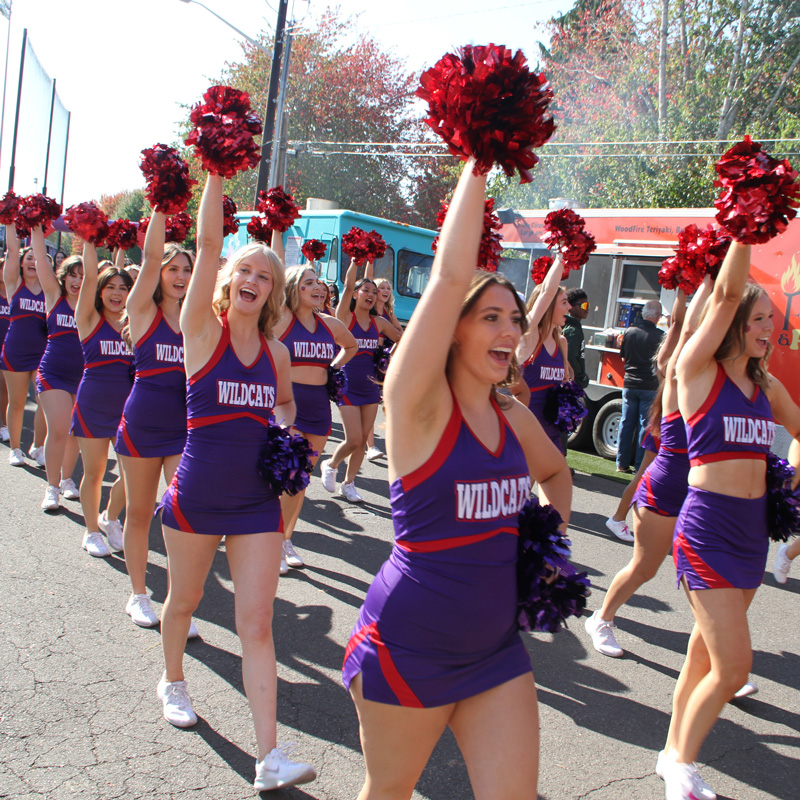 Cheerleaders walk down Streak Street, leading the fans in a chant