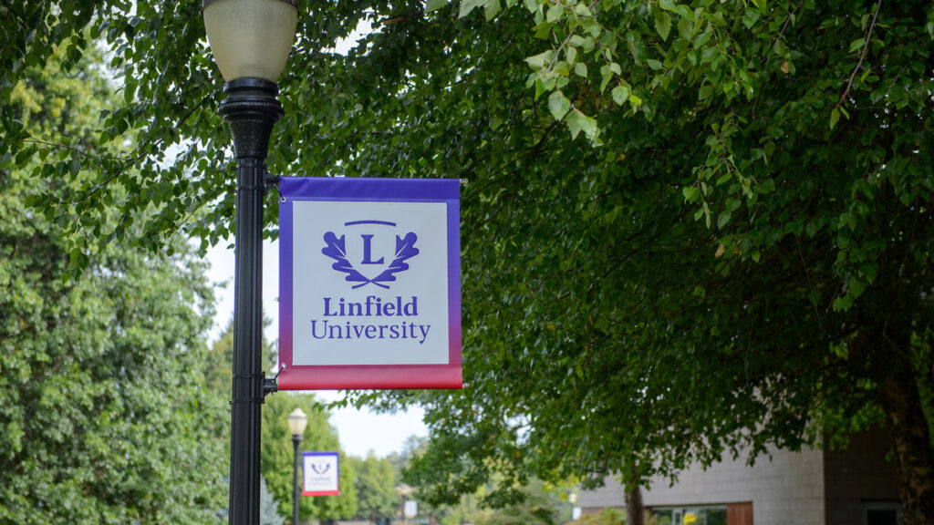 outdoor pathway lined with lamp posts bearing Linfield University banners