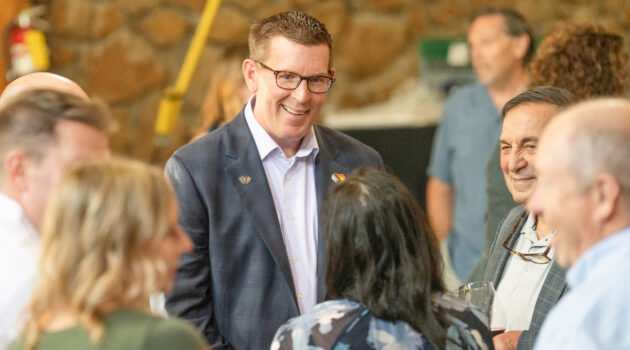 President Mark Blegen smiles and talks to a group of alumni and donors