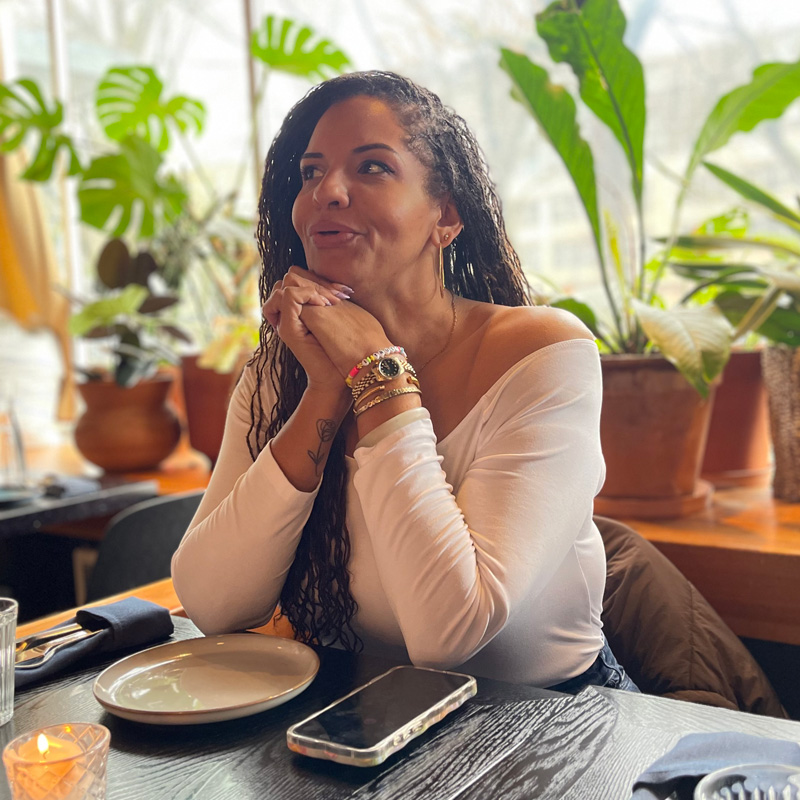 Tiquette Bramlett portrait at a table, looking off camera