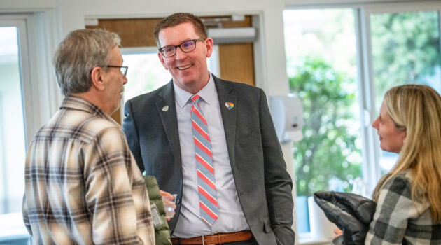 President Mark Blegen laughs and talks with two people