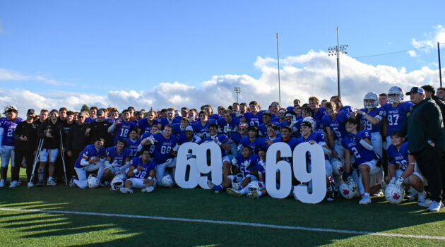 The Linfield football team poses with the number "69" after securing the team's 69th consecutive winning season.