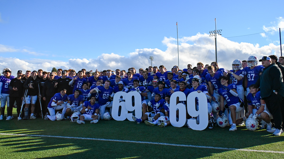 The Linfield football team poses with the number "69" after securing the team's 69th consecutive winning season.