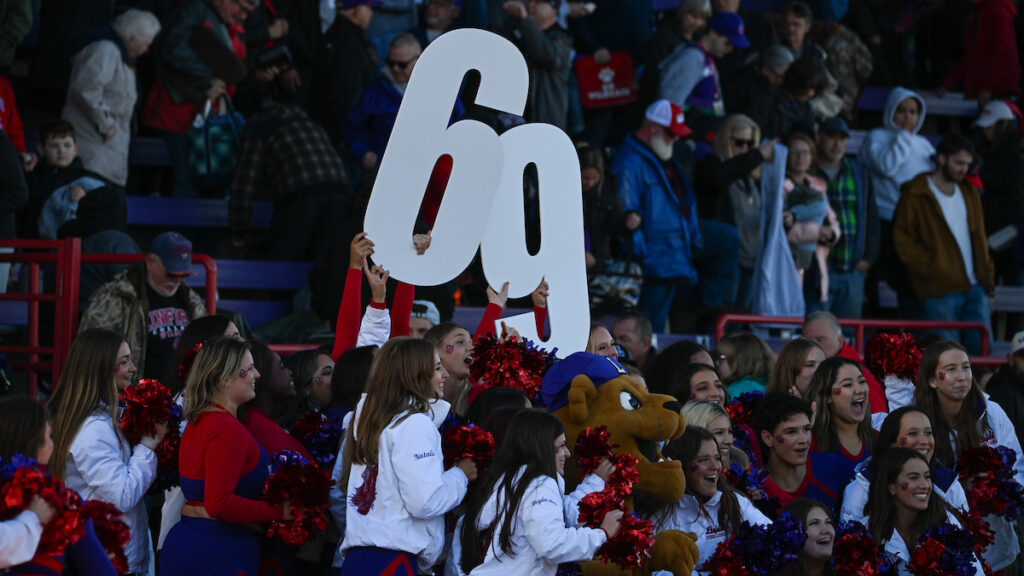 Cheerleaders hold up the numbers 69 in the football crowd