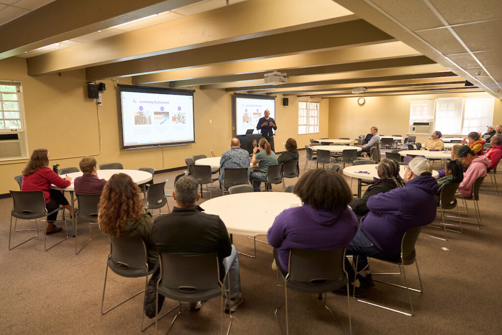 Assistant professor Enrique Washington speaks to a classroom full of people