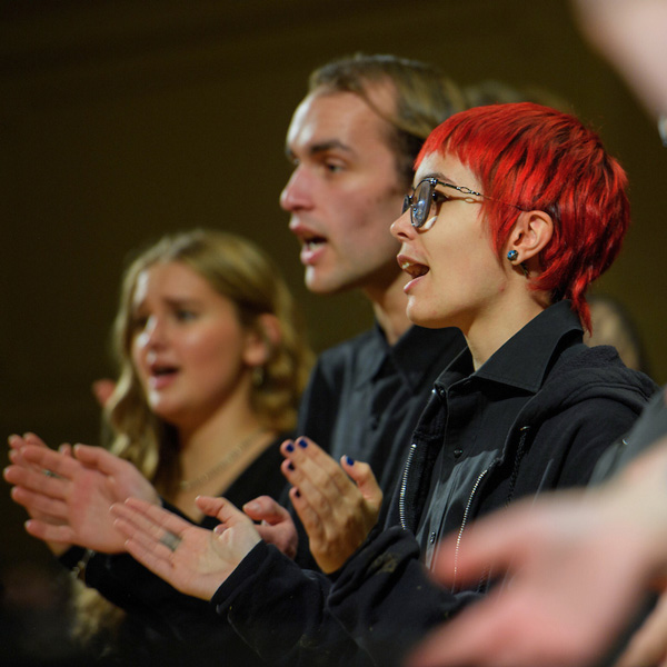 Group of choir members clapping and singing